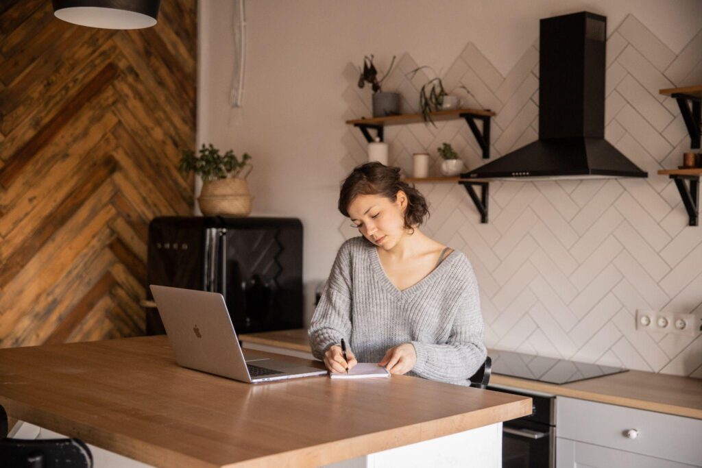 A person sitting at a desk with a computer Description automatically generated with medium confidence